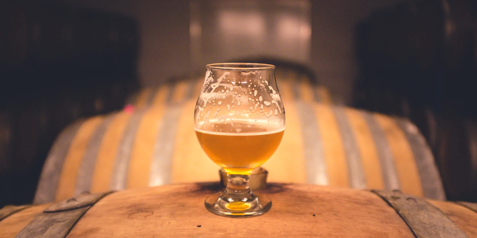 Bierglas auf Holzfässern